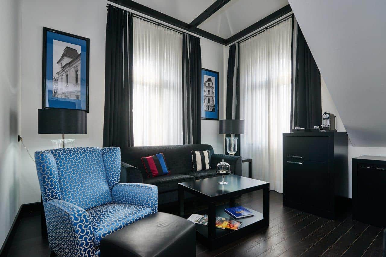 Luxuriös eingerichtetes Zimmer in der Turmsuite mit einer stilvollen Einrichtung in Schwarz und Blau.